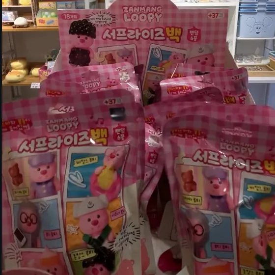 분홍 체크무늬 포장의 잔망루피 서프라이즈백(랜덤)이 진열대에 가득 꽂혀 있는 모습